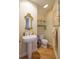 Small powder room with pedestal sink and glass shelving at 7503 Calle Facil, Sarasota, FL 34238