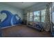 Bright bedroom with ocean-themed wall mural and comfy seating area at 7503 Calle Facil, Sarasota, FL 34238