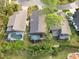 Aerial view of three homes with private pools and lush landscaping at 7755 Pine Trace Dr # 7755, Sarasota, FL 34243