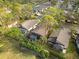 Aerial view showing three homes with screened pools and green surroundings at 7755 Pine Trace Dr # 7755, Sarasota, FL 34243