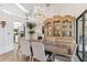 Elegant dining area with antique cabinet and modern chandelier at 7755 Pine Trace Dr # 7755, Sarasota, FL 34243