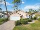 Tan house with white garage door and manicured landscaping at 7755 Pine Trace Dr # 7755, Sarasota, FL 34243