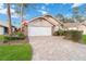 Brick home with a paved driveway and two-car garage at 7755 Pine Trace Dr # 7755, Sarasota, FL 34243