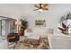 Living room with white sectional sofa, tropical art, and ceiling fan at 7755 Pine Trace Dr # 7755, Sarasota, FL 34243