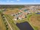 An aerial view of a house and surrounding community near a lake at 8208 Carrhill Pl, Parrish, FL 34219