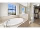 Relaxing bathroom featuring a garden tub, walk-in shower, and large window at 8208 Carrhill Pl, Parrish, FL 34219