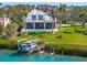 A beautiful home featuring a private dock, lush landscaping, and serene water views at 935 Bayshore Rd, Nokomis, FL 34275