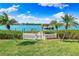 Lush backyard featuring a private dock, well-manicured lawn, and a white picket fence at 935 Bayshore Rd, Nokomis, FL 34275