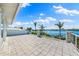 Spacious tiled balcony with stone accents overlooking a beautiful waterfront view and lush tropical landscaping at 935 Bayshore Rd, Nokomis, FL 34275