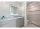 Stylish bathroom featuring gray vanity with blue countertop, illuminated mirror, and tiled shower at 935 Bayshore Rd, Nokomis, FL 34275