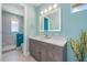 Bright bathroom featuring a gray vanity with white countertop, illuminated mirror, and tiled shower at 935 Bayshore Rd, Nokomis, FL 34275