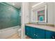 Contemporary bathroom featuring blue vanity, granite countertop, illuminated mirror, and walk-in shower at 935 Bayshore Rd, Nokomis, FL 34275