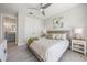 Bright bedroom featuring woven bed frame, ceiling fan, and ensuite bathroom access at 935 Bayshore Rd, Nokomis, FL 34275