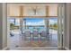 Outdoor patio with dining table has stunning views of pool and waterfront surrounded by palm trees at 935 Bayshore Rd, Nokomis, FL 34275