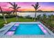 Aerial view of the luxurious pool and spa featuring fountains and a spacious deck with lounge seating at 935 Bayshore Rd, Nokomis, FL 34275