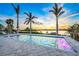 Inviting pool featuring fountains, elegant tile surround, and tranquil water views beneath palm trees at 935 Bayshore Rd, Nokomis, FL 34275