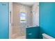 Walk-in shower with blue accent wall, glass partition, and window with water view at 935 Bayshore Rd, Nokomis, FL 34275