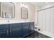 Modern bathroom with blue vanity, hexagon tile floor, and shower at 1012 Fernleaf Run, Bradenton, FL 34212