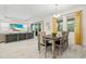 Bright dining room with farmhouse table and chairs, view of living room at 1012 Fernleaf Run, Bradenton, FL 34212