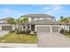 Two-story house with gray siding, three-car garage, and palm trees at 1012 Fernleaf Run, Bradenton, FL 34212