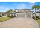 Two-story house with gray siding, three car garage, and palm trees at 1012 Fernleaf Run, Bradenton, FL 34212