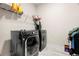 Functional laundry room with washer, dryer, and shelving at 1012 Fernleaf Run, Bradenton, FL 34212