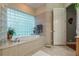 Elegant bathroom with a soaking tub and glass block window at 1130 Anclote Rd Rd, Tarpon Springs, FL 34689