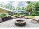 Stone fire pit with seating in a tranquil backyard setting at 1130 Anclote Rd Rd, Tarpon Springs, FL 34689