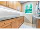 Laundry room with light wood cabinets, granite countertop, and window at 1130 Anclote Rd Rd, Tarpon Springs, FL 34689