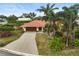 Single-Gathering house, terracotta roof, attached garage, tropical landscaping at 1212 Windward Dr, Osprey, FL 34229