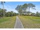 Paved pathway winds through lush landscaping, offering a serene community stroll at 1212 Windward Dr, Osprey, FL 34229