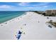 Aerial view of a beautiful beach with clear water and many people enjoying the sun at 1255 E Peppertree Dr # 402, Sarasota, FL 34242