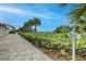 Walk to the beach via a paved path, lush landscaping and beach access sign at 1255 E Peppertree Dr # 402, Sarasota, FL 34242