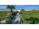 Beach walkway with a bench, offering scenic views and convenient beach access at 1255 E Peppertree Dr # 402, Sarasota, FL 34242