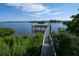 Wooden walkway leads to a pier over calm water, ideal for fishing or relaxing at 1255 E Peppertree Dr # 402, Sarasota, FL 34242