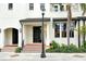 Townhome entrance with tiled steps, black door, and landscape at 1273 Boulevard Of The Arts, Sarasota, FL 34236