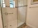 Clean shower with glass enclosure, neutral tile, and grab bar at 1273 Boulevard Of The Arts, Sarasota, FL 34236