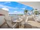 Spacious balcony with water views, outdoor furniture, and gorgeous sunset at 166 Golden Gate Pt # 21, Sarasota, FL 34236