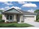 One-story home with light taupe siding, gray roof, and a two-car garage at 19591 Fort King Run, Brooksville, FL 34601