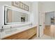 Modern bathroom with dual sinks, lighted mirror, and wood cabinets at 2008 Tocobaga Ln, Nokomis, FL 34275