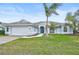 Single-story home with attached garage, landscaping, and palm tree at 2008 Tocobaga Ln, Nokomis, FL 34275