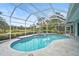 Relaxing kidney-shaped pool with a covered patio overlooking a pond at 2008 Tocobaga Ln, Nokomis, FL 34275