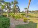 Landscaped backyard with tropical plants and a view of the golf course at 2115 Calusa Lakes Blvd, Nokomis, FL 34275