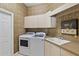 Bright laundry room with washer, dryer, and ample counter space at 2115 Calusa Lakes Blvd, Nokomis, FL 34275