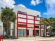 Modern white building with red accents, palm trees, and storefront at 2200 Fruitville Rd, Sarasota, FL 34237