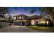 Two-story house with a stone facade, three-car garage, and landscaped yard at 2232 Elcid Ct, Palm Harbor, FL 34683