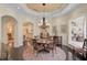 Elegant dining room with chandelier, hardwood floors, and views of the pool at 230 Osprey Point Dr, Osprey, FL 34229