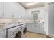 Bright laundry room with white cabinets and marble countertops at 230 Osprey Point Dr, Osprey, FL 34229