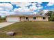 Single-story home with a two-car garage and well-maintained lawn at 2415 Nowatney Ave, North Port, FL 34286