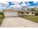 Single-story home with a white garage door and a landscaped lawn at 2415 Nowatney Ave, North Port, FL 34286